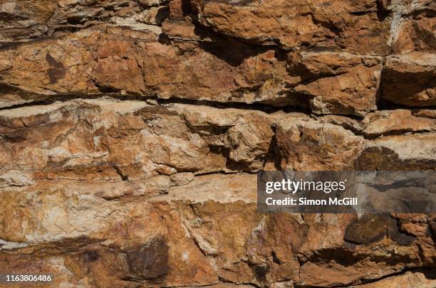 jagged orange sandstone rock face on the top of mount ainslie in canberra, australian capital territory, australia - cliff texture ストックフォトと画像