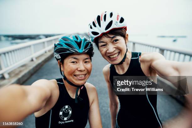 Visually impaired female triathlete taking taking a selfie with her guide and coach