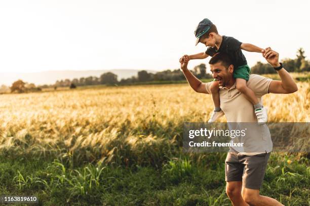 familia feliz, padre jugando con el hijo - llevar al hombro fotografías e imágenes de stock