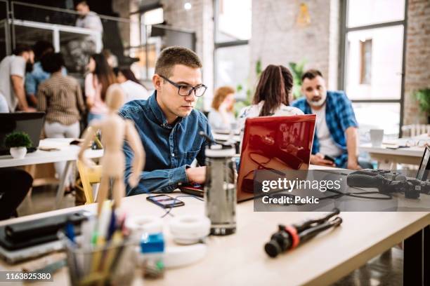 man having his job done at coworking office - reusable water bottle office stock pictures, royalty-free photos & images