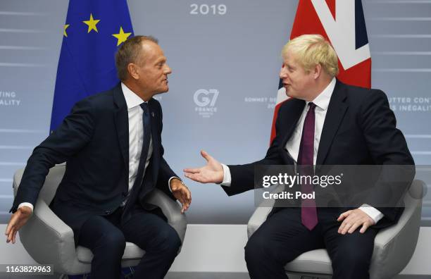 Britain's Prime Minister Boris Johnson meets European Union Council President Donald Tusk at a bilateral meeting during the G7 summit on August 25,...