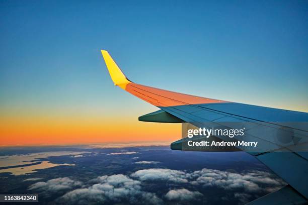 flying in airplane, airliner, aeroplane at high altitude with view of aircraft wing - aircraft wing stock pictures, royalty-free photos & images