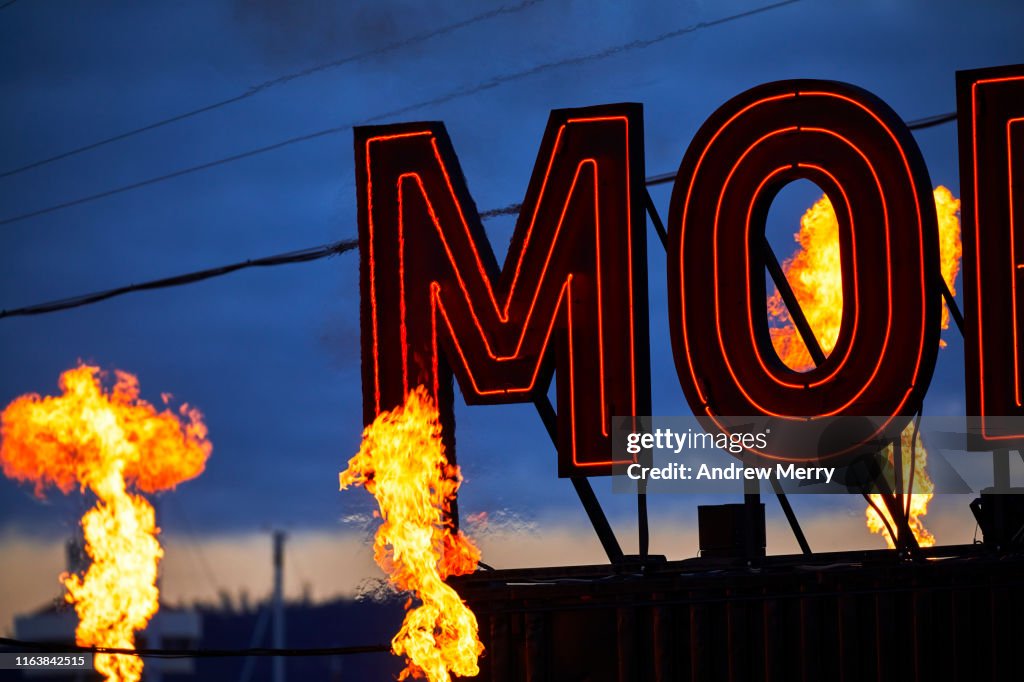 Dark MOFO neon sign glowing at night with fire