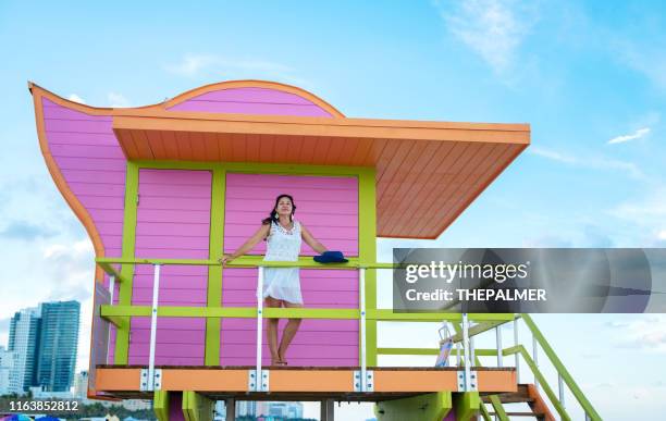 woman at a lifeguard hut in miami beach - lifeguard hut stock pictures, royalty-free photos & images