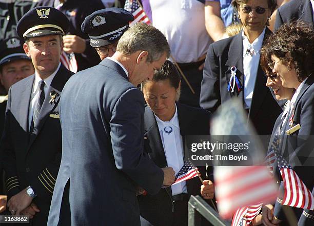 President George W. Bush autographs an airline employee's American flag after he spoke at a rally September 27, 2001 at O''Hare International Airport...