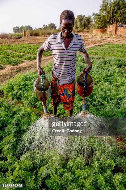 Woman watering a vegetable garden in Loumbila, Burkina Faso.
