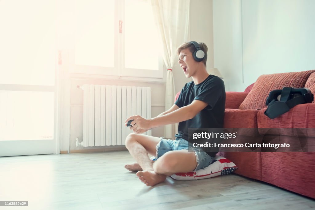 Teenage boy  playing at video game