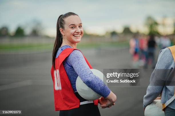 jonge vrouw gaat netball spelen - netball team stockfoto's en -beelden