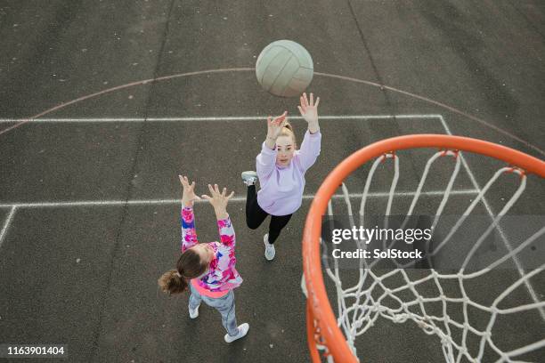 mädchen spielen netball - netball court stock-fotos und bilder