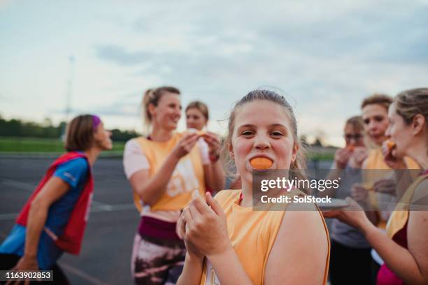 sinaasappelen eten na een netball spel - netball team stockfoto's en -beelden