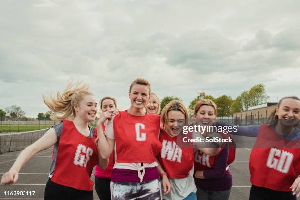 weibliches netball-team feiert einen sieg! - netball court stock-fotos und bilder