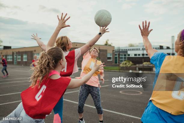 freunde spielen ein spiel von netball - netball court stock-fotos und bilder