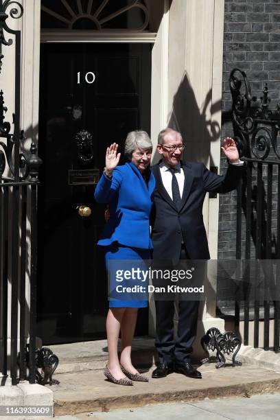 British Prime Minister Theresa May and her husband Philip May wave as she gives her outgoing statement in Downing Street on July 24, 2019 in London,...
