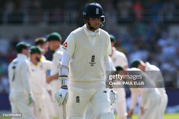 England's Chris Woakes walks back to the pavilion after losing his wicket on the fourth day of the third Ashes cricket Test match between England and...