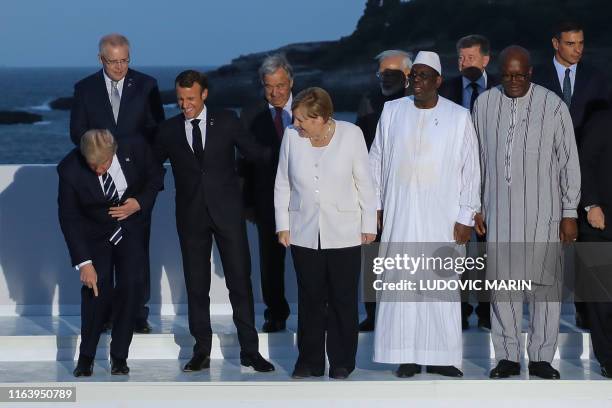 President Donald Trump gestures, flanked by France's President Emmanuel Macron, Germany's Chancellor Angela Merkel, Senegal's President Macky Sall...