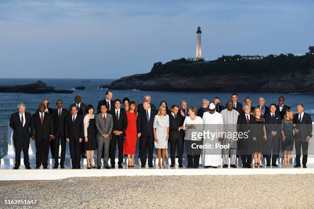 Leaders and guests pose for a family picture with the Biarritz lighthouse in the background on the second day of the annual G7 summit: L-R Britain's...