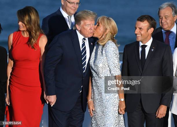 French President's wife Brigitte Macron kisses US President Donald Trump as G7 leaders and guests gather for a family picture in front of the...