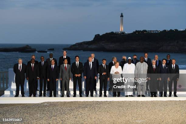 Leaders and guests pose for a family picture with the Biarritz lighthouse in the background on the second day of the annual G7 summit: L-R Britain's...