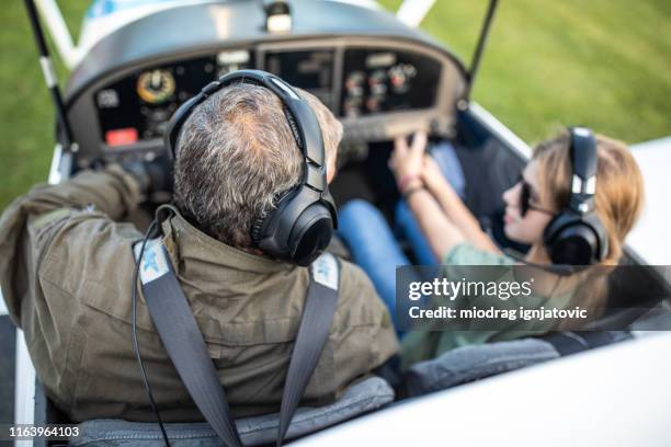 klein meisje en papa pilot binnenkant van het vliegtuig - propellervliegtuig stockfoto's en -beelden