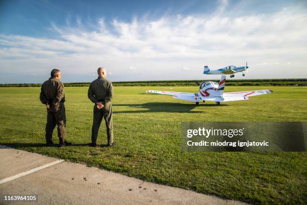 pilots watching airplane while taking off at the airport - airfield stock pictures, royalty-free photos & images