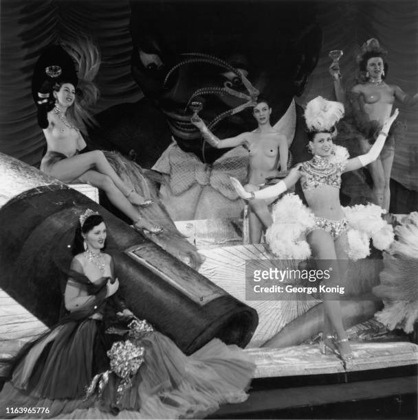 Fortunia dances, while models pose during 'Wine, Women & Song', a scene in a production of the show, 'Latin Quarter 1950' at the London Casino...