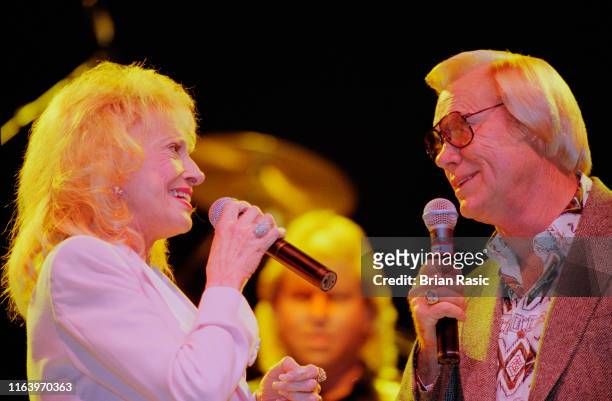 American country singers Tammy Wynette and George Jones perform live on stage together at Hammersmith Apollo in London in September 1995.