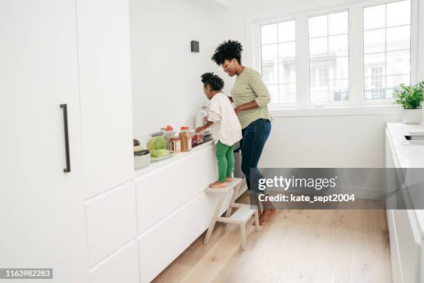 decluttering der küche mit hilfe der tochter - black mother and child cooking stock-fotos und bilder