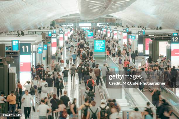 crowd commuters of pedestrian commuters in airport terminal - exibition fotografías e imágenes de stock