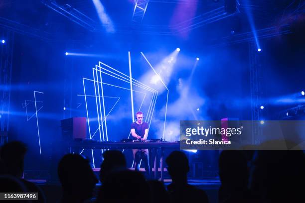 dj playing techno music on the stage - dj club stock pictures, royalty-free photos & images