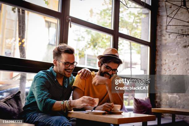 gay couple in a cafe. lgbt men - first date coffee shop stock pictures, royalty-free photos & images