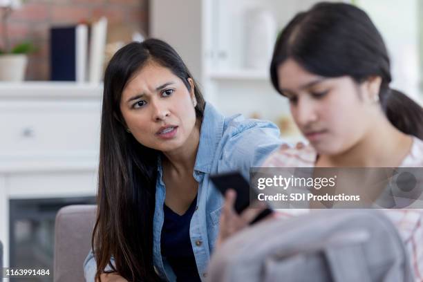 adolescente enojado ignora a mamá y se ve un teléfono inteligente - indiferente fotografías e imágenes de stock
