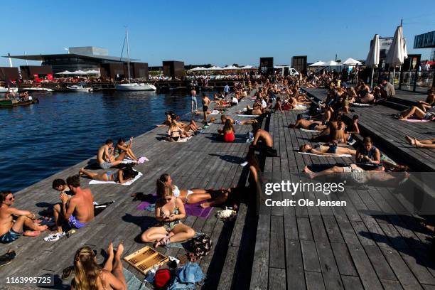 Locals and tourists at the pier near the Royal Danish Playhouse and Nyhavn on August 25, 2019 in Copenhagen, Denmark. The water in Copenhagen harbor...