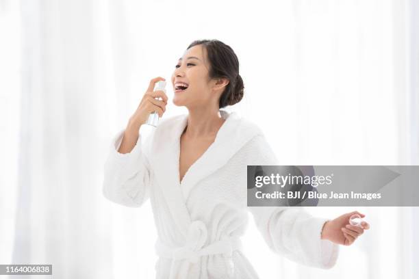 young chinese woman using mouth spray - mouth spray stock pictures, royalty-free photos & images