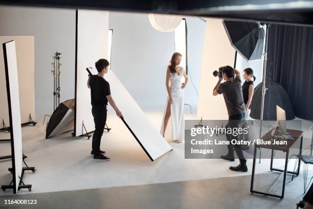 chinese photographer taking picture of model in studio - fashion photographer stock pictures, royalty-free photos & images