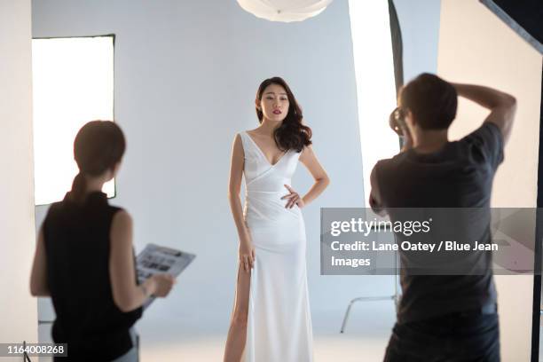 chinese photographer taking picture of model in studio - glamour asian stock pictures, royalty-free photos & images