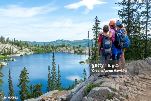 family admiring a panoramic scene above a mountain lake - lake mary in the wasatch mountains of utah - utah stock pictures, royalty-free photos & images