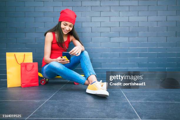 teenage girl using smart phone and credit card for shopping online - shopping credit card stock pictures, royalty-free photos & images