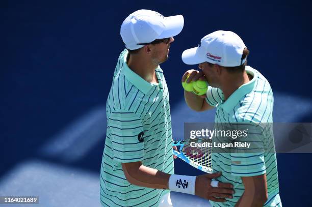 Bob Bryan talks to his brother and teammate Mike Bryan before serving to Christopher Eubanks and Donald Young during the BB&T Atlanta Open at...