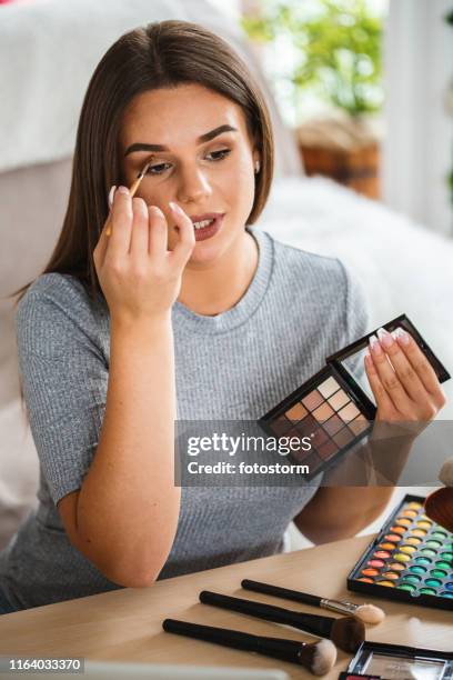 beautiful woman applying make-up - eye shadow stock pictures, royalty-free photos & images