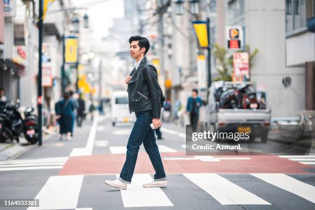 東京シマウマ交差点を歩く若い日本人男性 - レザージャケット ストックフォトと画像
