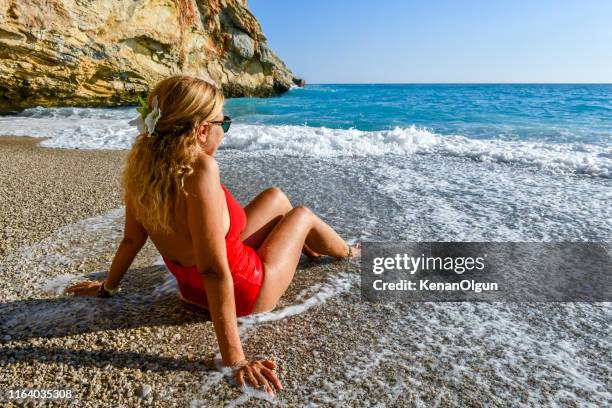 woman in red swimsuit having fun among the waves - antalya province stock pictures, royalty-free photos & images