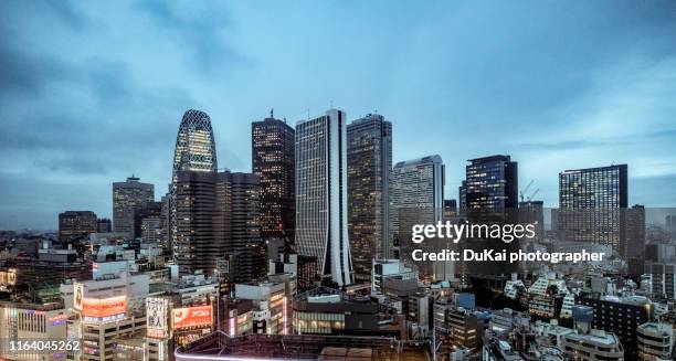 tokyo shinjuku district skyline at night - cloudy day office building stockfoto's en -beelden