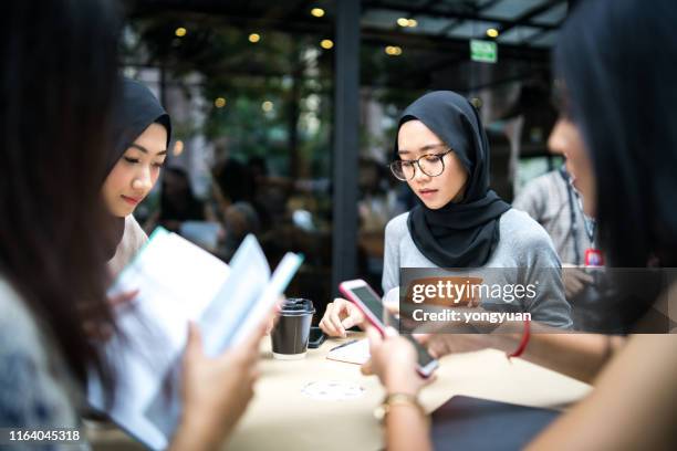 young malysian girls studying in a cafe - malaysia girl stock pictures, royalty-free photos & images