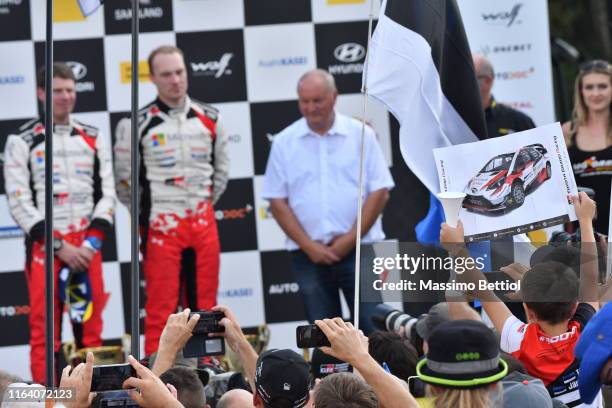 Fans look on as Jari Matti Latvala and Mikka Anttila of Finland celebrate an overall third position during Day Three of the FIA World Rally...