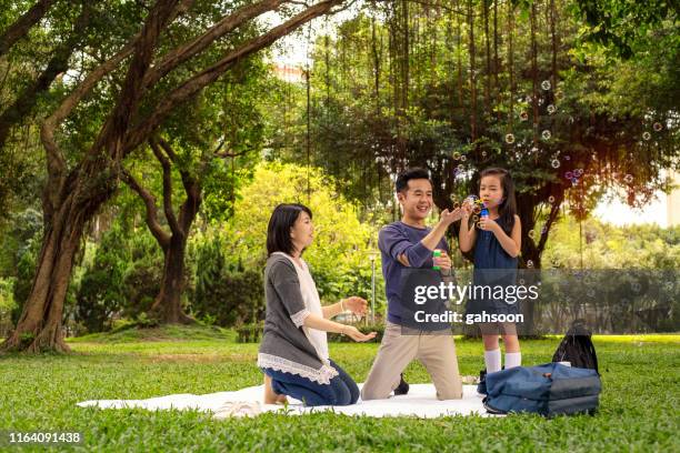 glücklich asiatische familie picknick und spielen im garten blasen blase, glücklich mit lächeln - family smile stock-fotos und bilder