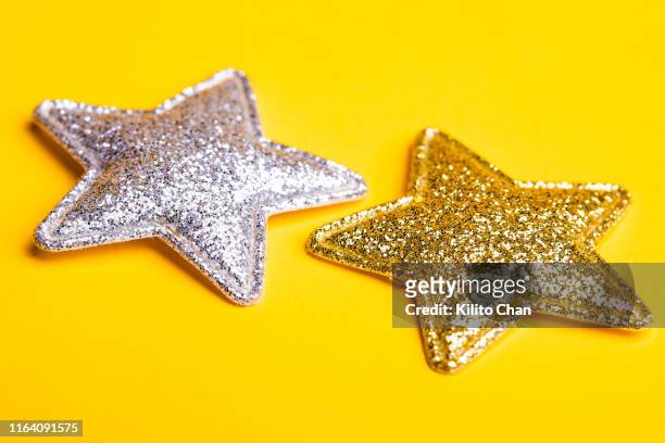 two stars against yellow background - silverstars stock pictures, royalty-free photos & images