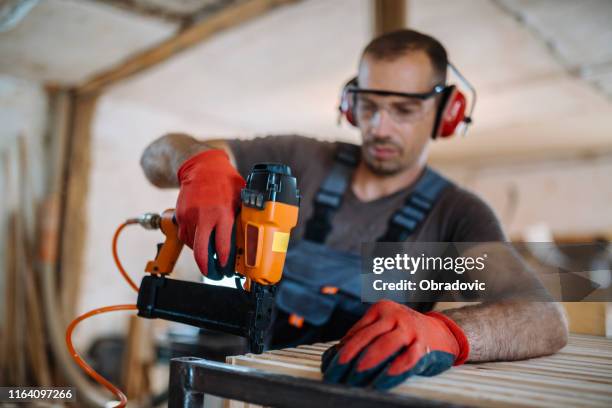 male carpenter working at his workshop stock photo - nail gun stock pictures, royalty-free photos & images