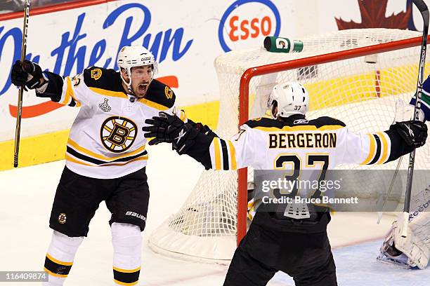 Patrice Bergeron of the Boston Bruins celebrates with his teammates Brad Marchand after scoring a goal in the first period against Roberto Luongo of...