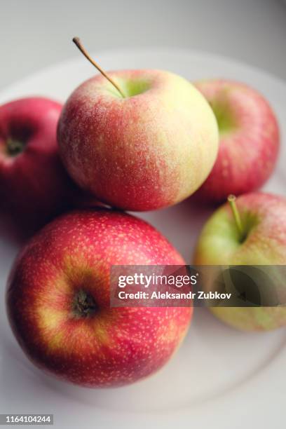 fresh red apples on a white plate. healthy diet. - cutting green apple stock pictures, royalty-free photos & images