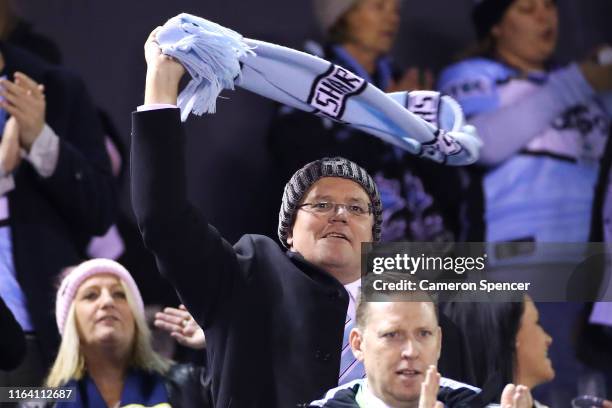 The Australian Prime Minister, Scott Morrison enjoys the atmosphere during the round 19 NRL match between the Cronulla Sharks and the North...